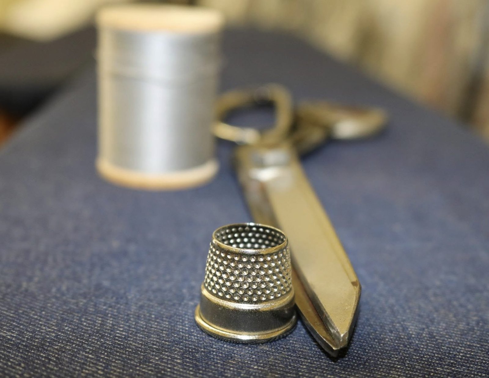 A tailor's thimble, shears and thread